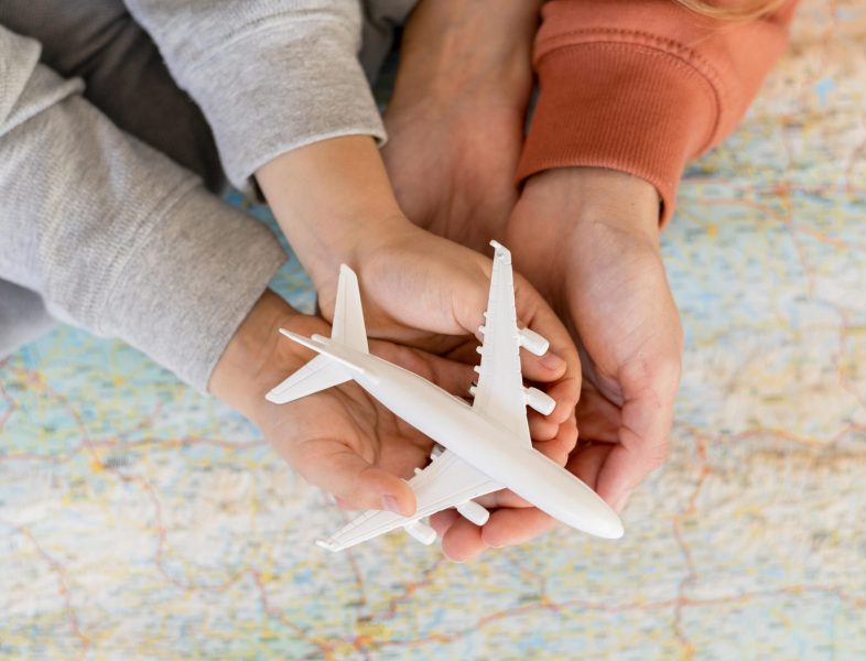 mother-child-home-holding-airplane-figurine-top-map